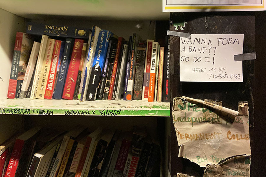 A bookshelf inside the venue features an invitation to start a band.