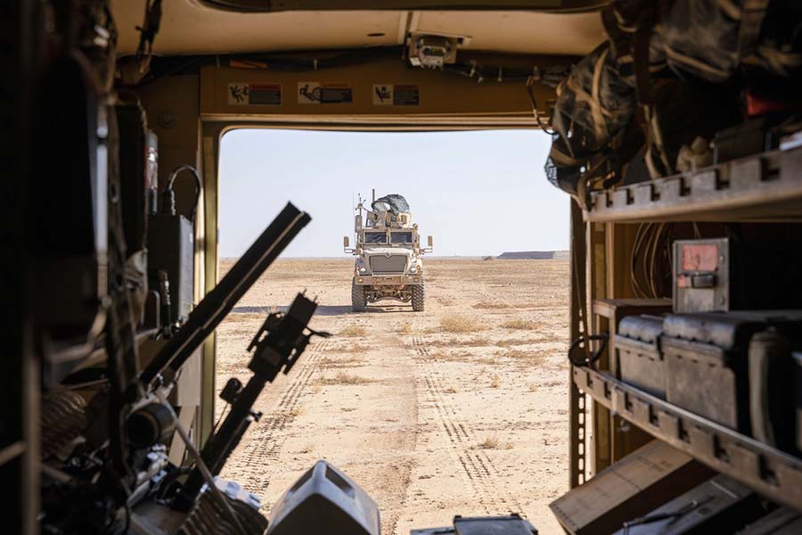 U.S. troops stationed at Al Asad Air Base in Iraq drive trucks on their way to conduct training exercises.