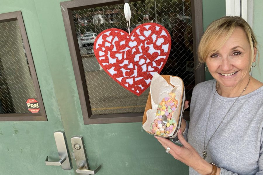 Attendance clerk, Ms. Audra Ward, shows off her box of Sweetheart candies, an iconic staple of Valentine's Day. 