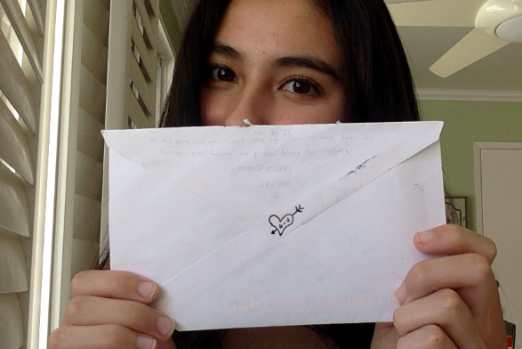 The author holds up a letter, complete with a heart on the back of the envelope, from her boo.