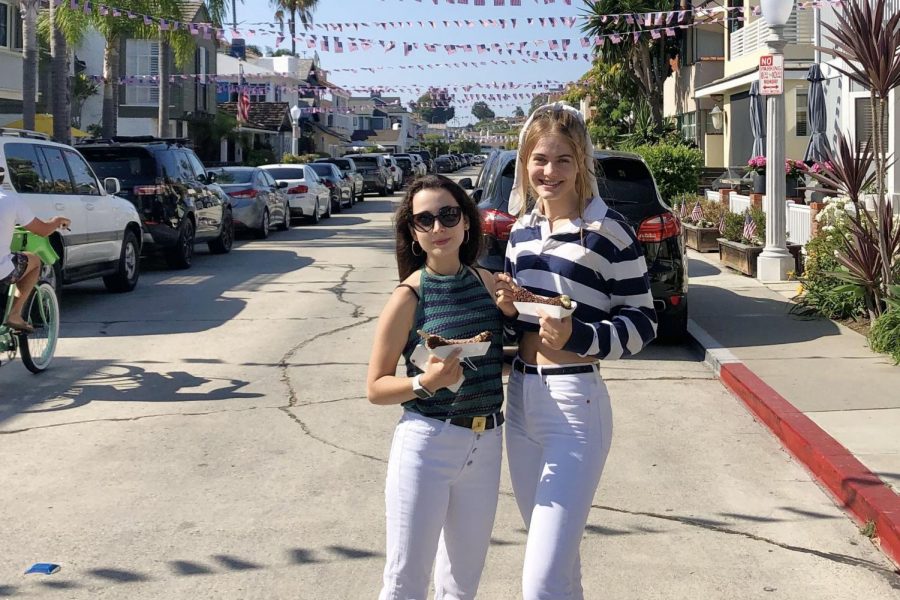 Looking like locals! Seniors Beatriz Giménez Cerezo and Emmie Barnard soak up the Newport sun, eat chocolate-covered bananas and match in white jeans. 
