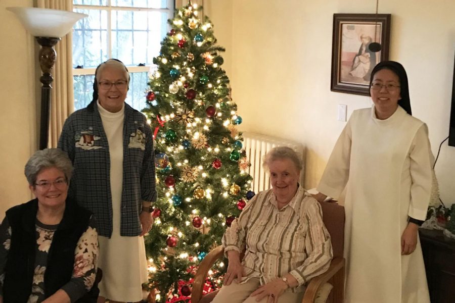 Sister Elizabeth, Sister Celeste, Sister Katherine Jean and Sister Mary (from left to right) pose in front of the tree in their community room. Sister Celeste's favorite ornaments were made out of straw by a sister in Germany. 