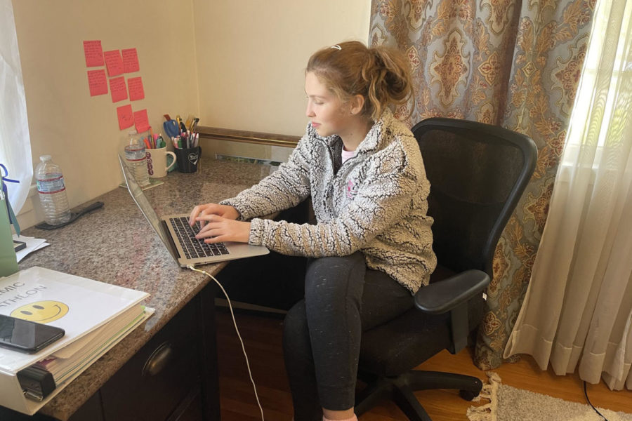Michelle St. Denis ‘22 finishes up a group assignment in Religion III in some comfy sweatpants and a Student Mission Committee sweatshirt -- an outfit better suited for Zoom than the Hill.