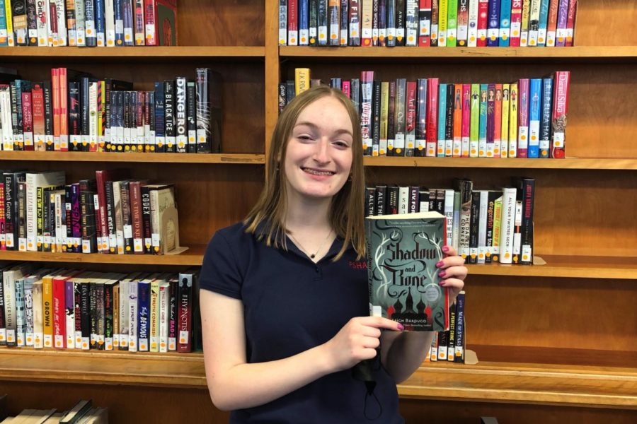 Julia Krider ‘23 poses with the first book from the “Shadow and Bone” series, which Netflix adapted for the screen in a show released in April. 
