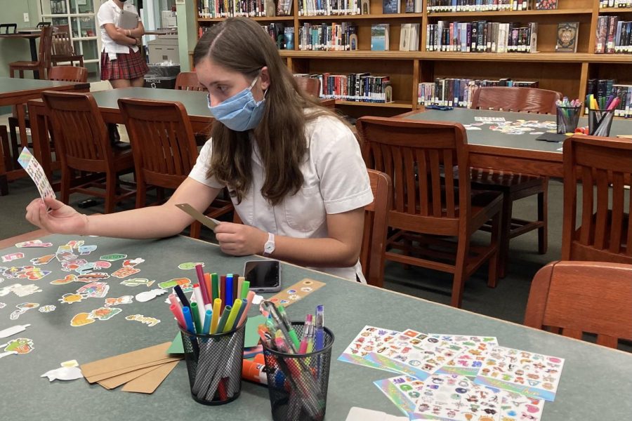 Adele Kelley ‘22 ponders the stickers at a bookmark-making event hosted by the school library. 