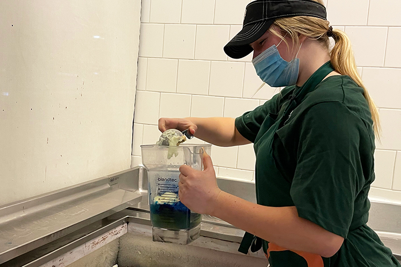 Aine MConville ‘22 ­­— in action and in uniform — takes a scoop of lime sherbert to whip up a delicious Electric Berry Lemonade smoothie. 