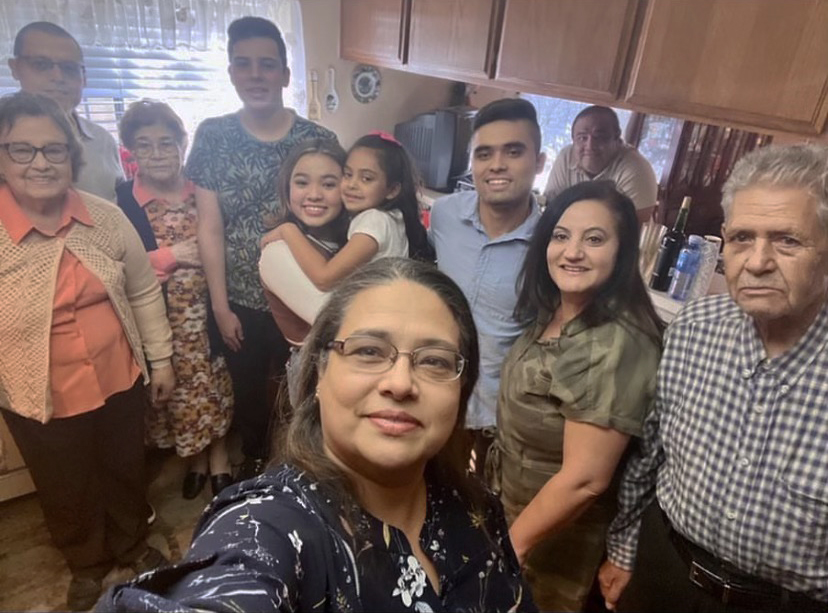 Sara Gutierrez ‘23 (holding her younger cousin) poses with family during a Christmas get together, excited to eat a freshly cooked meal of tamales, rice and beans. 
