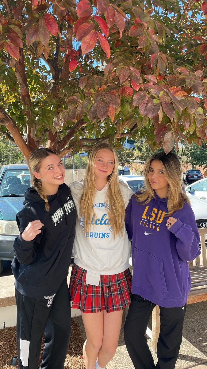 Ava Nawrocki '25, Piper Scherbert '25, and Emma Gordo '25 seen wearing sweatshirts of their favorite colleges and universities. 