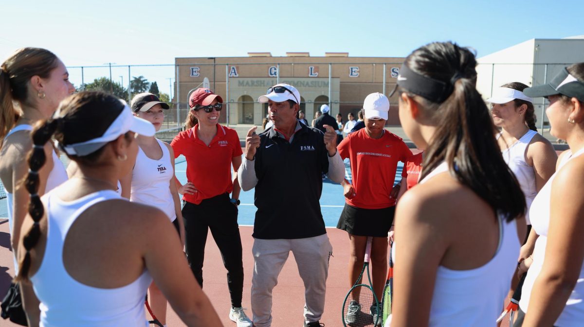 The tennis team seen in a huddle led by Coach Ron Zambrano and Coach Isabel “G” Gutierrez. Photo by Eric Lopez.